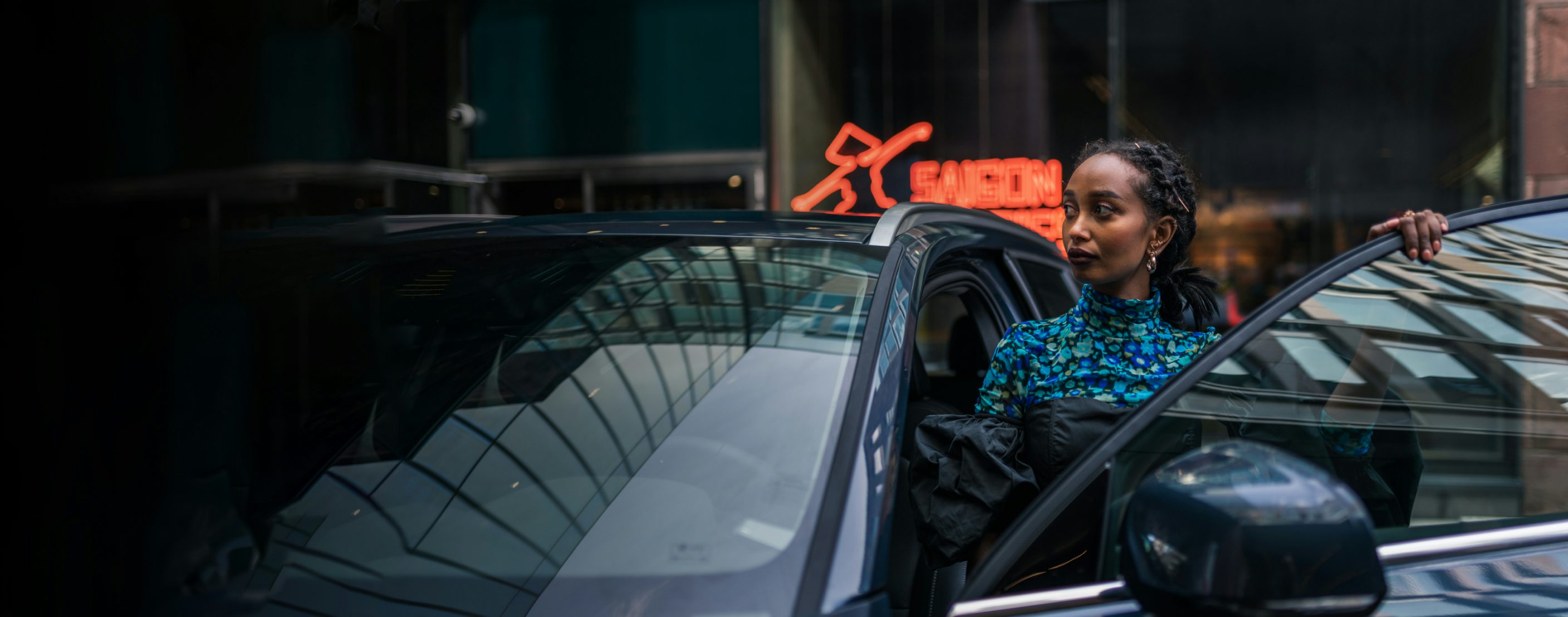 Affärsklädd kvinna på väg att sätta sig i en Volvo parkerad i ett affärsdistrikt